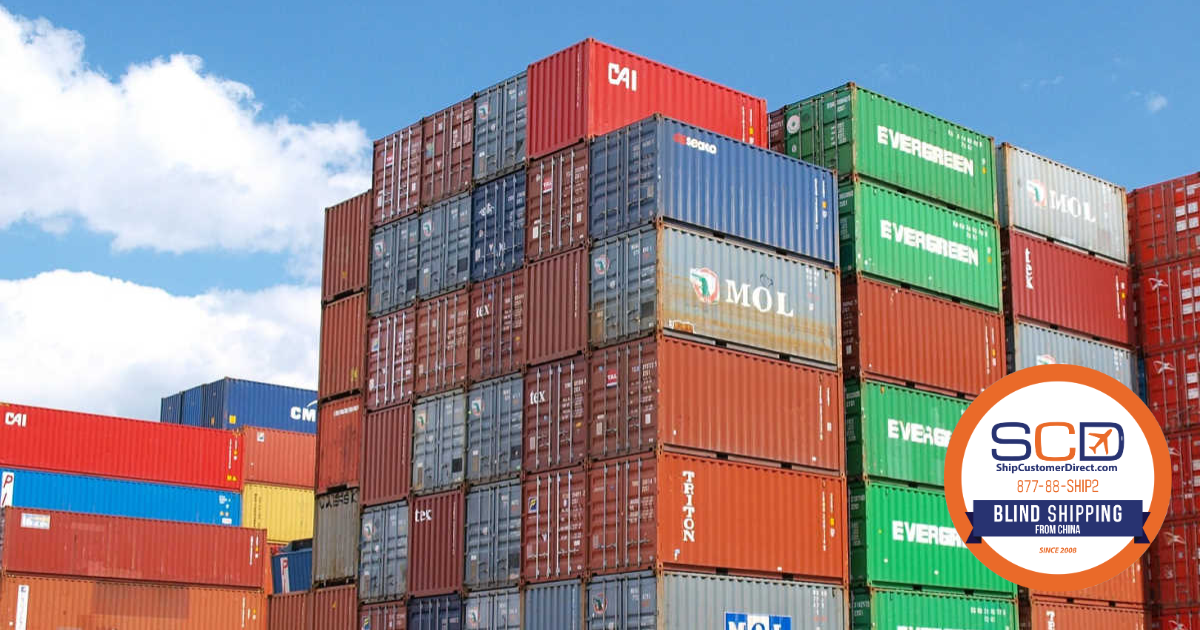 Stacked shipping containers at a freight yard under a blue sky